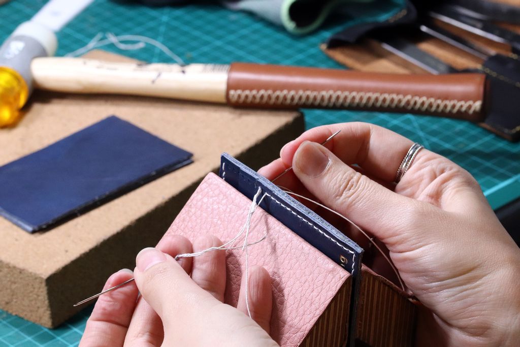 A handcrafted leather good being sewn together. 