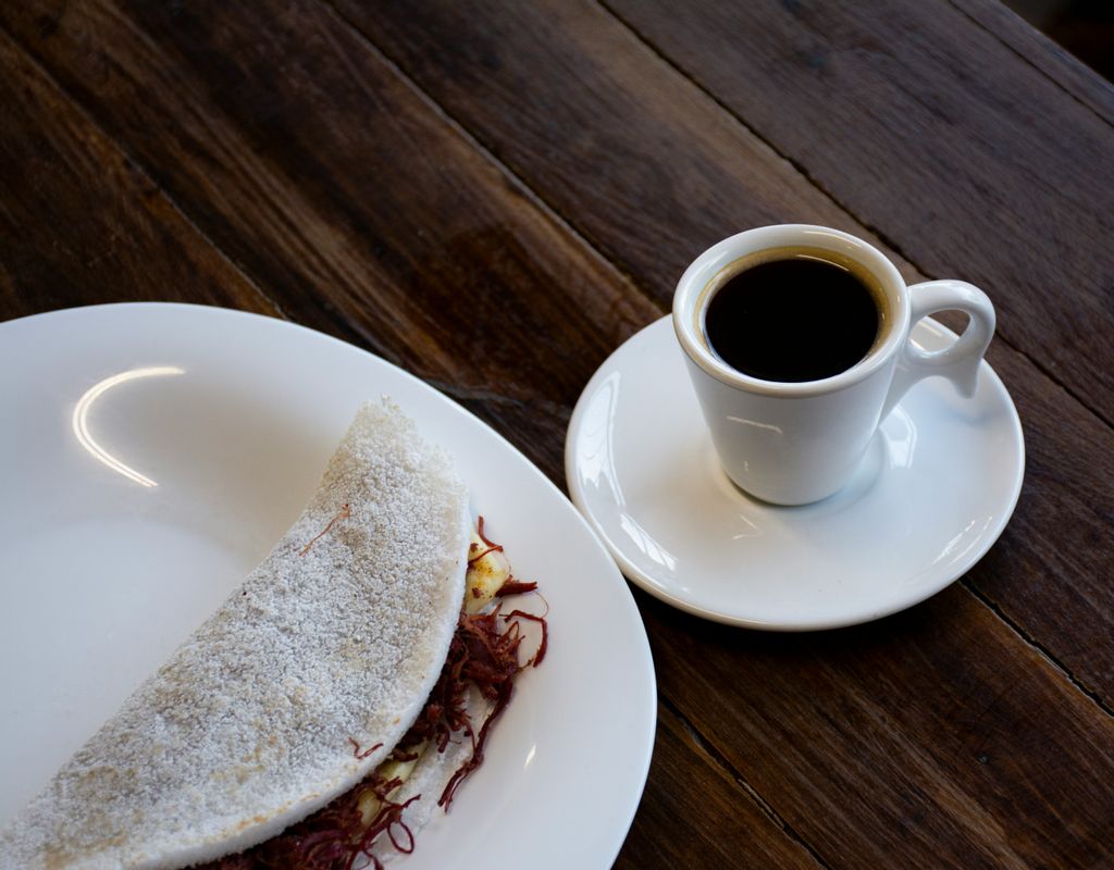 A Brazilian tapioca crepe with a small cup of espresso coffee