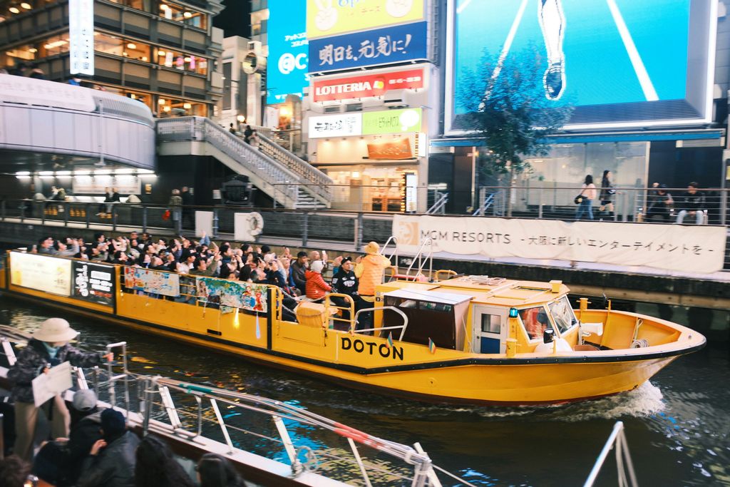 people in a yellow boat tour of Dotonbori's river