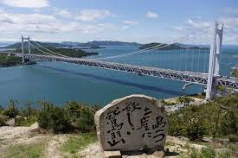 Okayama Private Tour - This is Seto Inland Sea and Seto ohashi Bridge.  It is in Kojima in Kurashiki City. You can see many small islands there. It is a very beautiful scenery. On the stone monument in the center is written the poem  meaning ‘I am on the hill called Washuzan. I see many islands. They are beautiful.  I want to take one island  as a souvenir.’ If you have time, you can enjoy cruising in the Seto Inland Sea from the port at the bottom of  Washuzan Hill.