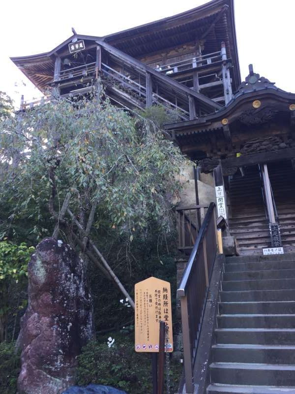 Chiba Private Tour - Kasamori-kannon Temple. The main hall is designated as a National Important Cultural Property and is the only example of the "Shiho-Kakezukuri" architectural style in Japan. 
Sixty-one stilts stand atop a large rock with overhanging scaffoldings supporting the main hall. 
It should be a bit scary experience to go up the wooden steps on a large rock.  