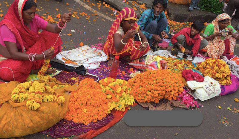 Jaipur Private Tour - women using fresh flowers to make garlands .