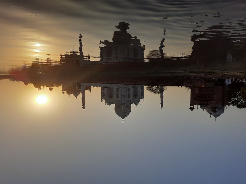 Delhi Private Tour - The sunset view of the Taj Mahal is a mesmerizing spectacle that bathes this iconic monument in a warm, golden light. As the sun dips below the horizon, the pristine white marble of the Taj Mahal takes on a serene and ethereal glow. 