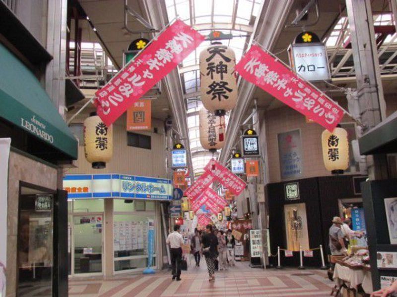 Osaka Private Tour - "Girl's portable shrine of Tenjin Festival" is written in red banners.