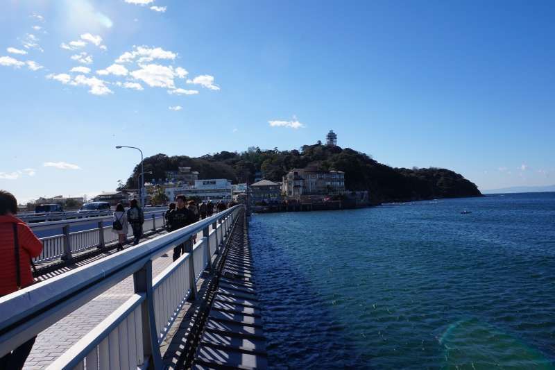 Kanagawa Private Tour - L'île d'Enoshima se situe à 400 mètre du continent. C'était pendant la marée descendente que les pèlerins ont pu faire accès à l'île en traversant la mer avant la construction d'un pont à l'ère Meiji comme au Mont-Saint-Michel de France au moyen âge. c'est la raison pour laquelle nous l'appelons " Mont-Saint-Michel au Japon"!!