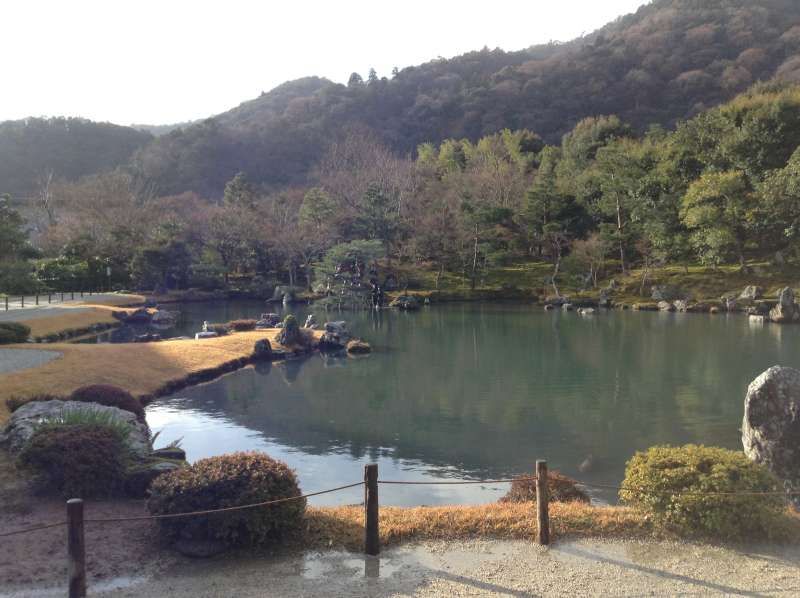 Kyoto Private Tour - -Sougen-pond garden in Tenryuu-temple (World heritage)
About 700 years ago in Muromati period, Tenryuu temple was built by Takauji Ashikaga who established the Muromati Shogunate. He built the temple to console the spirit of Emperor Godaigo who was originally his political opponent. 
Square Hut garden, or Sougen pond garden, was built by Musousoseki as pond and spring strolling garden. It is also landscape borrowing garden which borrows Arashiyama and Kameyama behind with strolling trail around Sougen pond in the center of the garden. Originally this garden was designed for viewing from big square hut, so let’s go to big square hut to see this garden.