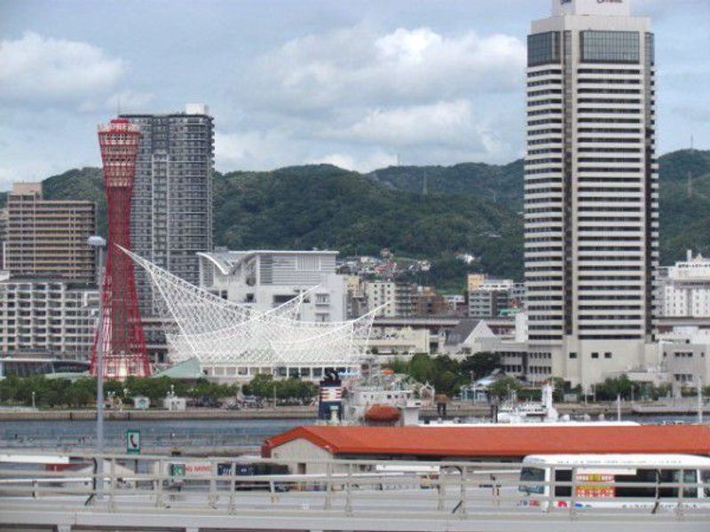 Kobe Private Tour - The red Port Tower, the city's landmark, creates a beautiful contrast against the white Kobe Marine Museum, inspired by waves and sailing ships.