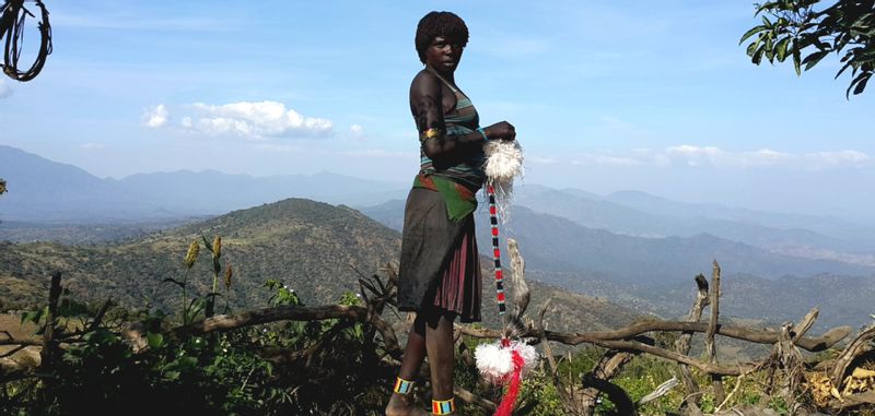 Addis Ababa Private Tour - A woman of Benna tribe making jewelry while looking after the crops.