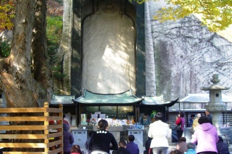 Seoul Private Tour - Constant worship at the 1145-year-old carved Buddha in the top courtyard.